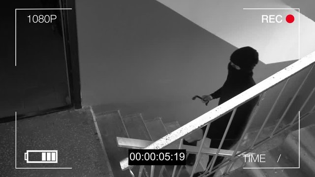 the masked robber breaks removing the surveillance camera mount.