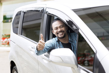 Afro man showing thumbs up in his car