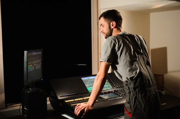 A lighting engineer works with lights technicians control on the concert show. Professional light...
