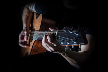 Young man playing a guitar.