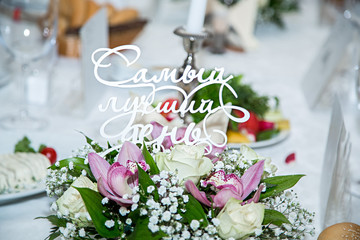 свадебный стол сервированный цветами и надписью 