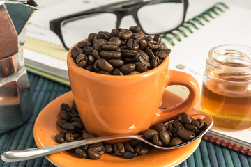 cup of coffee with honey, lens and a moka