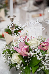 свадебный стол сервированный цветами и надписью 