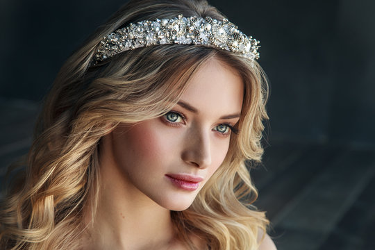 Fashion portrait of model with crown on the metal background