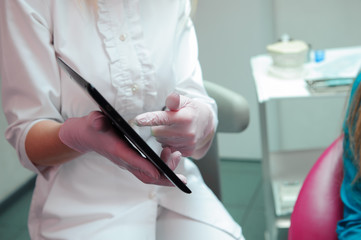 female dentist with patient girl talking at dental clinic office