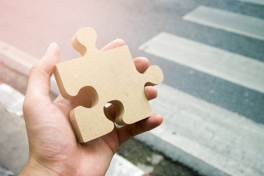 hand hold the wood jigsaw in business plan concept
