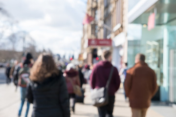 Fototapeta premium Blurred image of People walking on the street, with car, building in background. On Princes Street, the main shopping street in Edinburgh, United Kingdom.