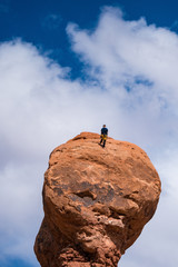 Rock climber on top of a hoodoo, Utah