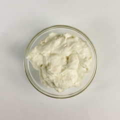 Bechamel in a transparent bowl on white background - top view