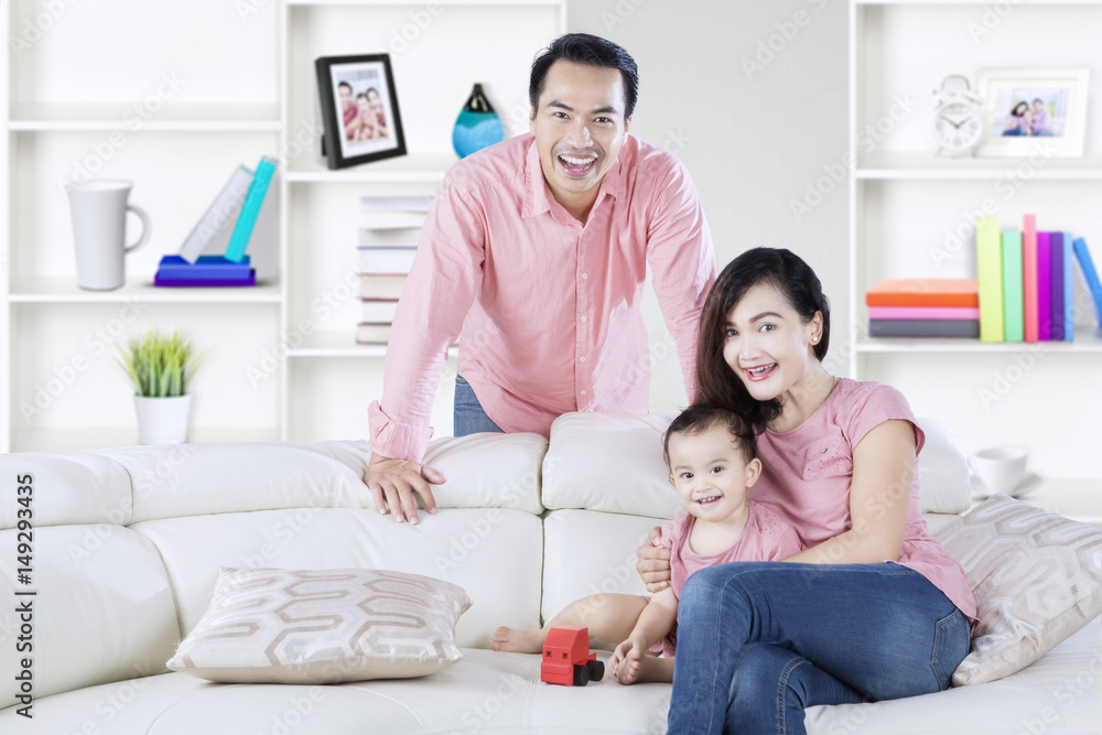 Poster Cute girl playing toy with parents