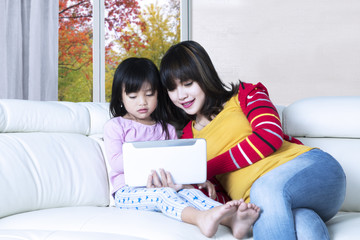 Cute mother and daughter use tablet