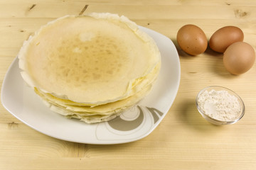 Crepes on wooden background - top view