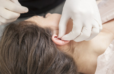 Obraz na płótnie Canvas Professional making rook piercing in the ear