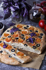 Italian focaccia with tomatoes, black olives and basil