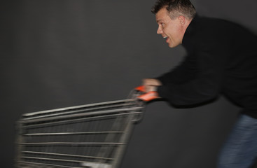 Ein Mann schiebt einen Einkaufswagen