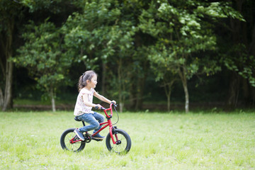 Fototapeta premium 赤い自転車に乗る女の子
