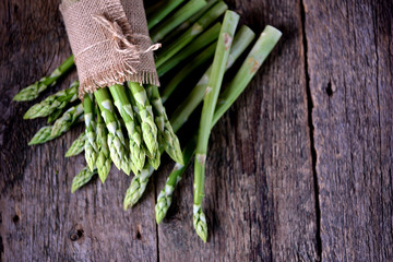 Fresh green asparagus on an old wooden background. Healthy food.