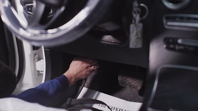 Technician prepares for preliminary treatment of control package in car service. Any work connected with repair of engine electronic control module has to be carried out only after professional