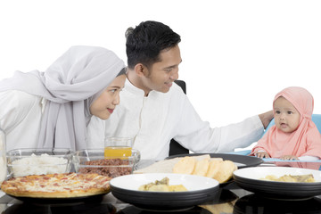 Muslim parents having meal with daughter