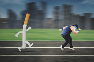 Fototapeta premium Obese man running away from a cigarette