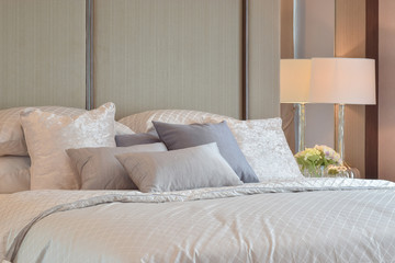 Classic bedroom interior with pillows and reading lamp on bedside table