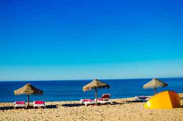 Fototapeta na wymiar Beach umbrellas and couches on outdoors blue sky background