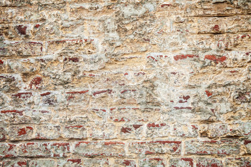 Cracked plaster on the brickwall, grunge background of brown bricks