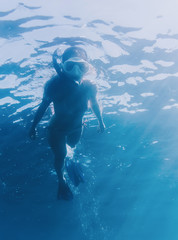 Female freediver snorkeling underwater.