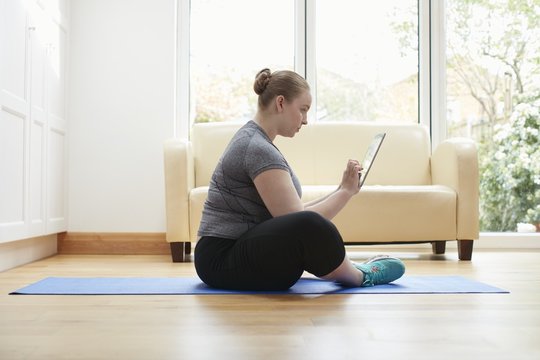 Woman sitting on floor using digital tablet