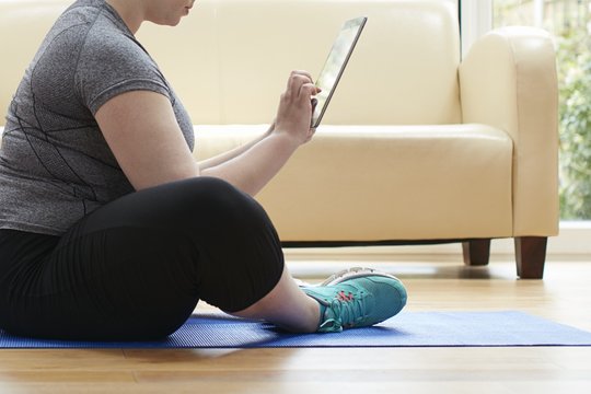 Woman sitting on floor using digital tablet