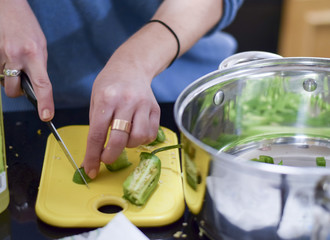 Woman chopping jalapeno peppers