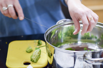 Woman chopping jalapeno peppers