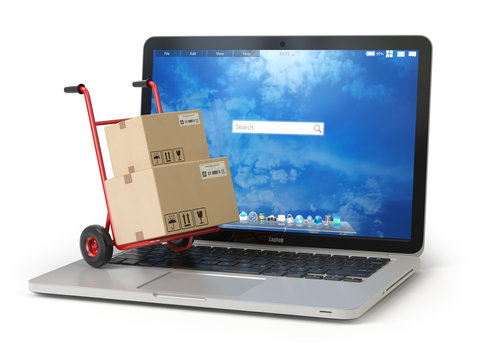 E-commerce, online shopping and delivery concept. Hand truck and cardboard boxes on PC laptop keyboard.