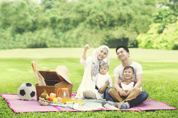 Young family looking at something in the park