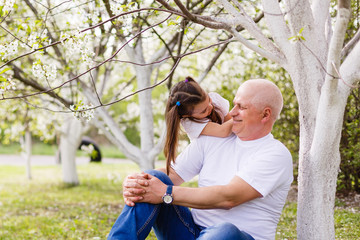 grandfather and his little granddaughter together in garden
