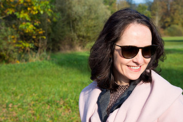 Young cute woman walking in a park on a nice sunny autumn afternoon