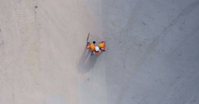 Aerial shot of three construction engineers on a bridge construction site