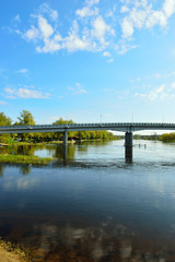 Fototapeta na wymiar Most nad rzeką, brzegiem i drzewa w Pułtusku.
