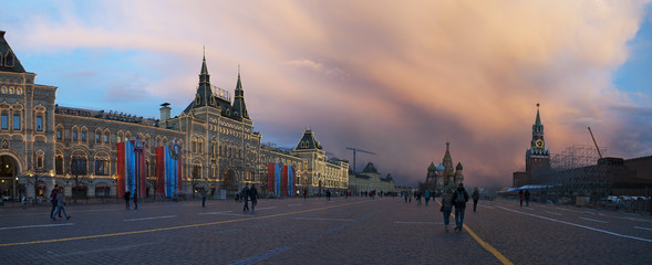 Fototapeta na wymiar Mosca, 25/04/2017: tramonto sulla Piazza Rossa con le mura del Cremlino, la Torre Spasskaja, la Cattedrale di San Basilio e il centro commerciale Gum