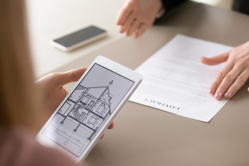 Real estate agency clients holding tablet, looking at architectural plan of dream house, considering mortgage, loan for buying suburban housing. Renters choosing accommodation to lease or rent