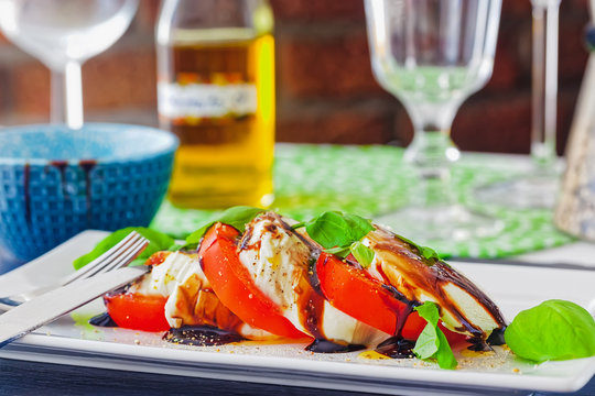 Tomate-Mozzarella in Scheiben geschnitten und seviert auf einem Teller
