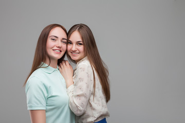 Two women hugs together, studio photo shoot