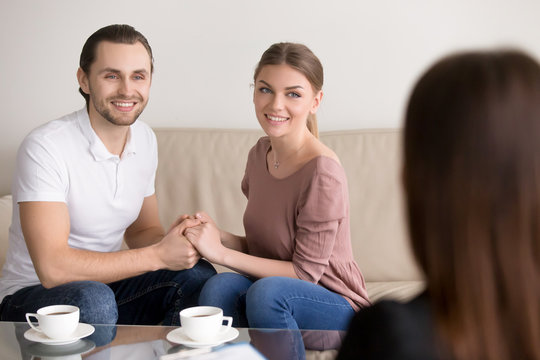 Happy young couple hold each other s hands listening to female agent, planning wedding, consulting investment advisor, hearing good news, casual marriage registration, buying real estate