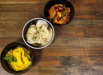 Set of different dumplings and ravioli on a wooden table