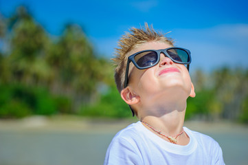 Adorable boy having fun on the tropical beach. Close-up portrait