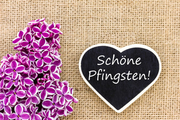 eine Herzförmige Tafel und Flieder für Pfingsten