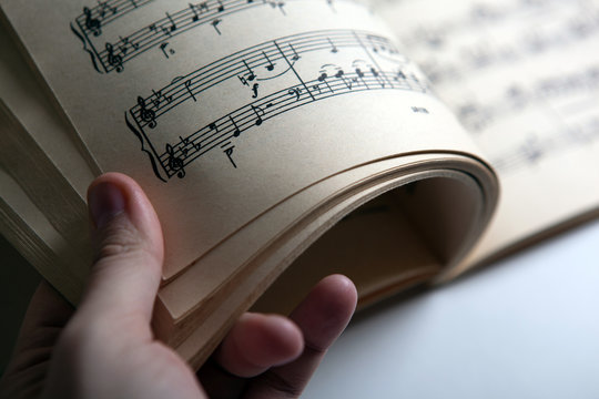 Open Large Music Book And Human Hand