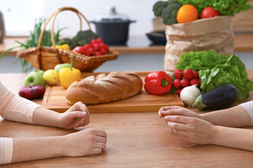 Two women discussing a new menu in the kitchen, close up. Human hands of two persons gesticulating...