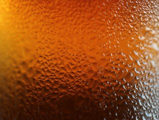 Macro shot of water drops texture on the deep orange color bottle, for abstract background with selective focus 