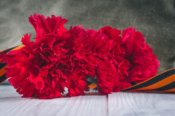 Carnation flowers, George Ribbon and military garrison cap with a red star. May 9 Victory Day